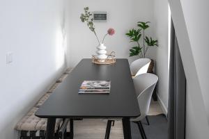 a black dining room table with a vase on it at 6p newly renovated home with unique roof-terrace in Strijp