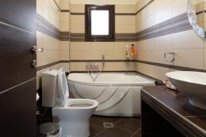Un baño con bañera, inodoro y lavabo. en The Sunset Haven Kastoria - Modern Lake Elegance, en Kastoria 18 fotos más