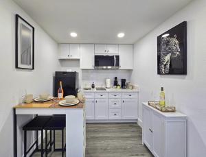 a kitchen with white cabinets and a table with chairs at The Executive Landing , 1BR, 7 TPA Airport, AC, Free Pkng, Wine, Fast Wi-Fi in Tampa