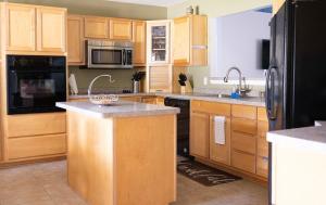 a kitchen with wooden cabinets and stainless steel appliances at The Breeze in Navarre