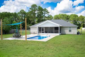a house with a swimming pool in a yard at The Breeze in Navarre