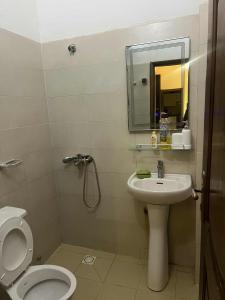 a bathroom with a sink and a toilet and a mirror at Doumassou Studio in Dakar
