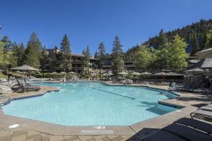 ein großer Pool mit Stühlen und Sonnenschirmen in einem Resort in der Unterkunft Everline Resort & Spa #718 & #720 in Olympic Valley