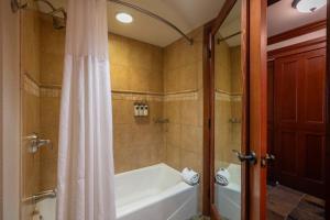 ein Badezimmer mit Badewanne und Dusche mit Duschvorhang in der Unterkunft Everline Resort & Spa #718 & #720 in Olympic Valley + 19 Fotos