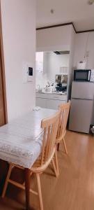 a kitchen with a table and two chairs and a refrigerator at Sea Bloom Hotel in Dejimamachi