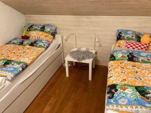 two beds in a room with a table and a chair at Chalet 87 Engelberg, Cosy Chalet with Superb Views in Engelberg