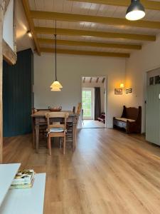 a dining room with a table and a couch at Kleinhoef - charmante, luxe kamers in een boerderij uit 1875 in Nigtevecht
