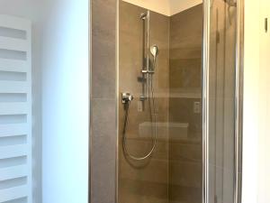 拉斯特德Ferienwohnung FLORI的浴室里有玻璃门的淋浴间 更多10张照片