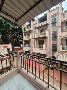 une vue du balcon d'un immeuble rose avec balcons dans l'établissement Elite Stays Viman Nagar, à Pune 22 autres photos