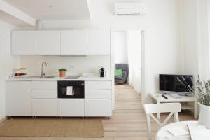 a white kitchen with a sink and a microwave at The Riverside Suite in Mira