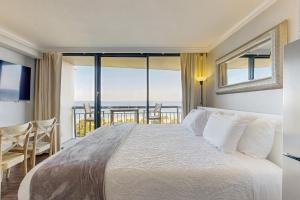 Un dormitorio con una cama con vista al mar. en Sunset Dream, en Galveston