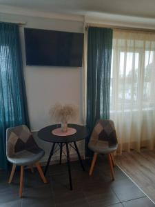 een eetkamer met een tafel en twee stoelen bij Studio Apartment 2 in Rēzekne