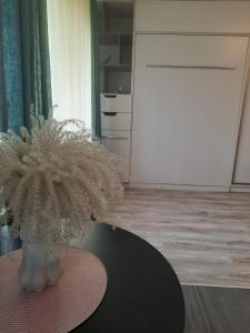 een vaas met bloemen op een tafel in een kamer bij Studio Apartment 2 in Rēzekne