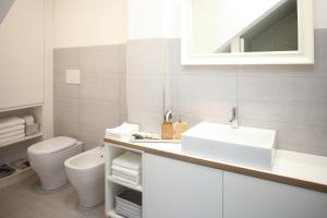 a white bathroom with a sink and a toilet at The Riverside Suite in Mira