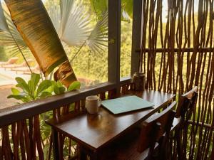 a wooden table in a room with a window at Elvis Surf Shack at Casa Akaw in Temalhuacán