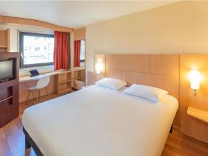 a bedroom with a large white bed and a desk at ibis Paris 17 Clichy-Batignolles in Paris +120 photos