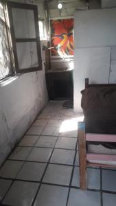 Habitación con cama y suelo de baldosa. en piesa una noche, en San Carlos