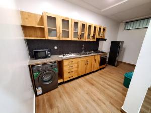 a kitchen with a sink and a washing machine at Cotonou Bois Fleuri Suites - Le Loft Naturel A2 in Cotonou