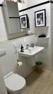 a bathroom with a white sink and a toilet at Modern & Cozy Apartment Münchner Freiheit with Balcony in Munich