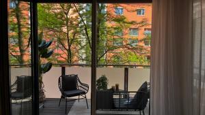 a balcony with chairs and a table and a window at Modern & Cozy Apartment Münchner Freiheit with Balcony in Munich +5 photos