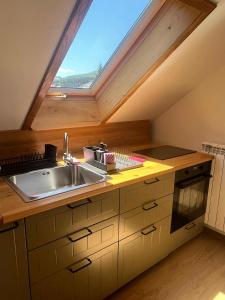 a kitchen with a sink and a window at Iedera Bucovinei in Suceviţa
