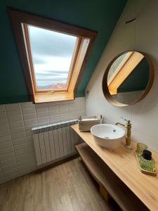 a bathroom with a sink and a mirror and a window at Iedera Bucovinei in Suceviţa +22 photos