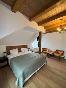 a bedroom with a large bed and a chair at Iedera Bucovinei in Suceviţa