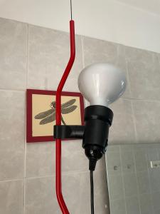 a light with a red cord attached to a wall at B&B Al 27 in Paderno dʼAdda +17 photos
