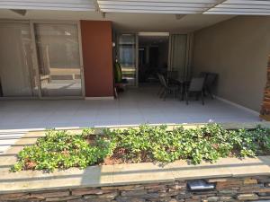 un porche de una casa con mesa y sillas en Isibaya holiday leisure, en Sibaya
