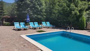 a group of blue chairs and a swimming pool at Pension Curmatura Stezii in Răşinari