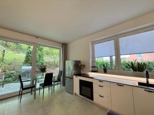 ワルシャワにあるLeśny apartament z ogrodemのキッチン(テーブル、椅子、窓付)