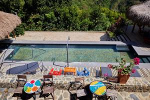 a swimming pool with chairs and umbrellas next to at Finca La Manchuria in Salgar