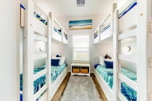 two beds in a room with blue and white bunk beds at Amazing Gulf Views Large Deck Family Fun in Hercules Offshore Heliport