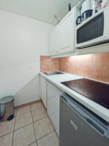 ボーソレイユにあるJosephine 325, Casino 5 Min, Rickeysの白いキャビネットとシンクと電子レンジを備えたキッチン