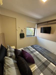a bedroom with a bed and a flat screen tv at Studio novo e completo in Uberlândia +17 photos