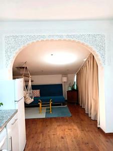 a living room with a blue couch and an archway at Apartamentos María Gaviota 2 in Prado del Rey