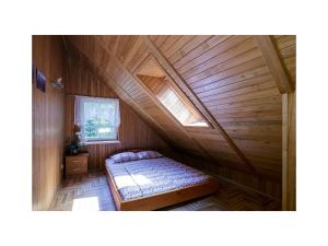 NeringaにあるForest Cottageのベッドと窓が備わる屋根裏部屋