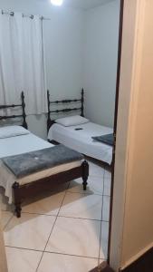 two beds in a room with a mirror at Hotel Eldorado in Eldorado +2 photos