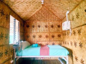 um pequeno quarto com uma cama no canto em Hilltop chalet, with AC, private bathroom, kitchen & balcony with views em Coron