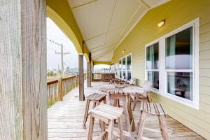 a porch with chairs and tables on a building at Ultimate Steps to Beach Large Deck Dog Haven in Crystal Beach