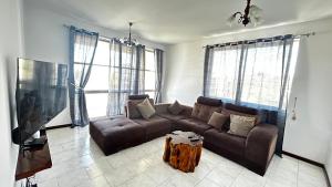 a living room with a brown couch and a table at Casa Fortes in Praia