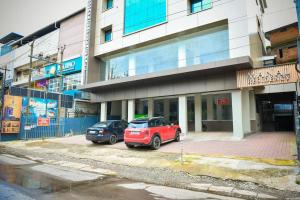 a red suv parked in front of a building at Hotel Manal Suites in Green Island
