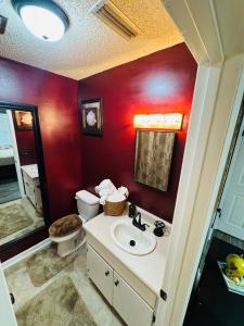 a bathroom with a sink and a toilet and red walls at Home Away from Home in Fitzgerald +53 photos