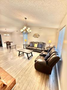 a living room with a leather couch and a table at Home Away from Home in Fitzgerald