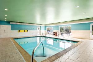 a large swimming pool in a house with blue walls at Holiday Inn Express & Suites - Detroit Northwest - Livonia by IHG in Livonia