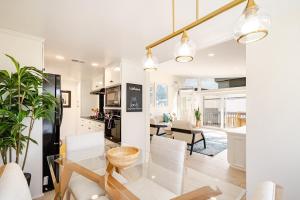 a kitchen and living room with white walls and a table and chairs at Amazing location, Unique Oceanfront Beach House! in Manhattan Beach