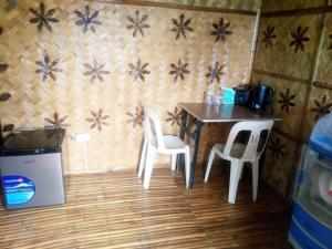 un tavolino e due sedie in una stanza di Hilltop chalet, with AC, private bathroom, kitchen & balcony with views a Coron