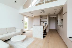 ein Wohnzimmer mit Sofa und Tisch in der Unterkunft Domein Mase - Luxe vakantiewoningen aan de Maas in Maaseik in Maaseik