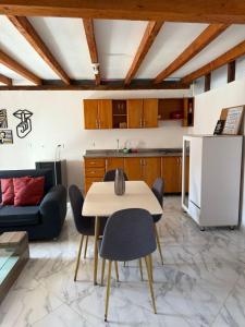 a kitchen and living room with a table and chairs at Casa Madeira in Rionegro