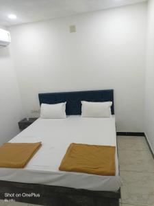 a bedroom with a large white bed with two pillows at Dwarka Sai Palace in Dwarka